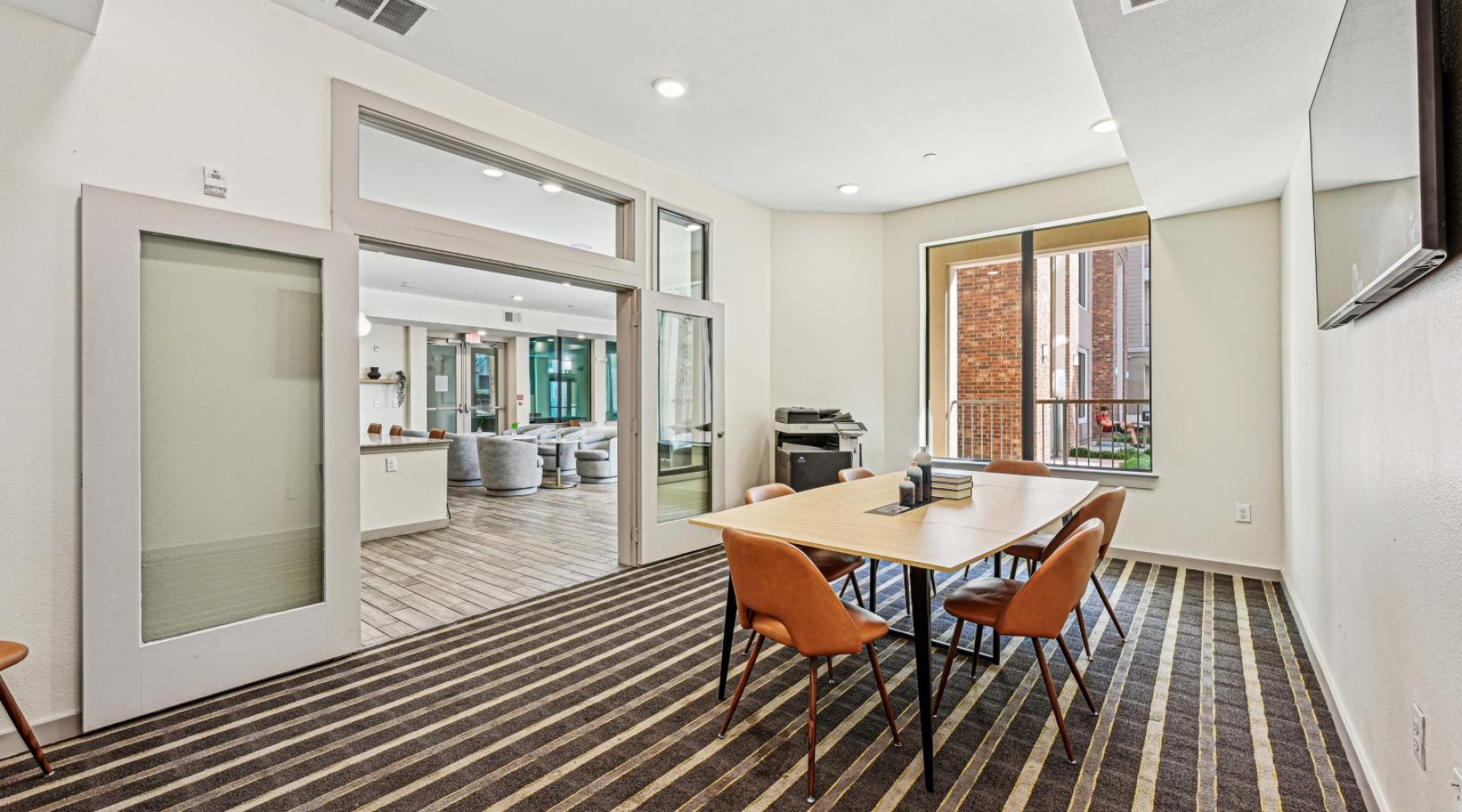 a private clubhouse room with a large glass door and a tv