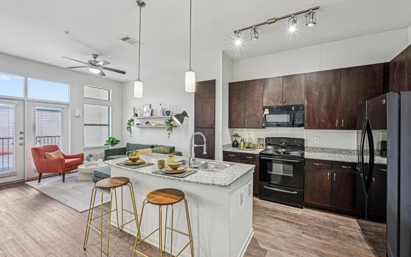 a kitchen with a table, chairs and wood cabinets